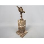 A bronzed flying lady in the form of Spirit of Ecstasy set on a marble plinth,
