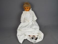 Antique doll- wax face, wooden limbs and stuffed body. Length 75cm.