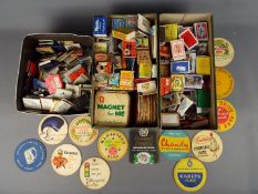 A large quantity of vintage matchboxes, matchbooks and beer mats, three boxes in total.