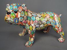 A ceramic bulldog decorated with a bottle top design,