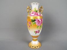 A mid-century twin handled vase decorated with roses against a peach ground,