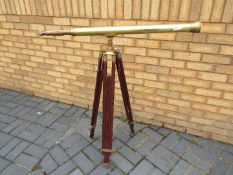 A brass telescope on wood and brass, adjustable, tripod stand,