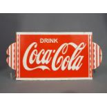 An enamelled sign advertising Coca Cola,