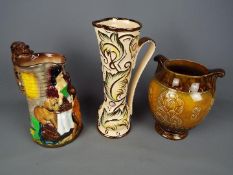 A Wade 'Gothic' pattern jug, Burleigh Ware 'Old Feeding Time' jug and a Crown Devon vase,