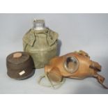 A gas mask with canister and War Department issued field canteen and pouch.