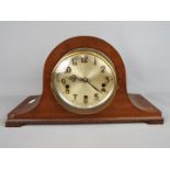 A Napoleons hat mantel clock with carved detailing, Arabic numerals to the dial, with pendulum.