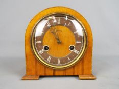 A small Smiths wood cased mantel clock with Roman numeral chapter ring, movement marked 'Smiths'.
