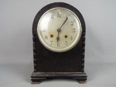 An arch top mantel clock with Arabic numerals to the dial, with key and pendulum.