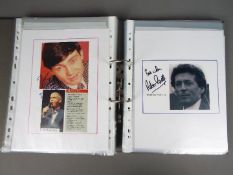 A binder containing a collection of signed photographs and press clippings to include Brian Blessed,