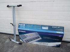 A Yamaha keyboard, model PSR-E313, contained in original box and a keyboard stand.