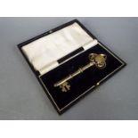 A George V silver gilt and enamel presentation key contained in fitted case, Birmingham assay 1926.