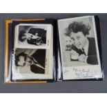 An album containing a quantity of autographs and signed promotional photos including Ken Dodd,