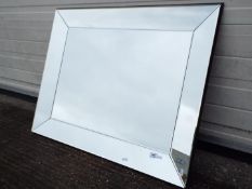 A large contemporary wall mirror, approximately 70 cm x 90 cm.