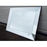 A large contemporary wall mirror, approximately 70 cm x 90 cm.