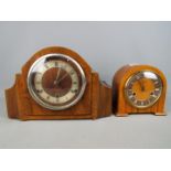 A wood cased mantel clock with Roman numeral chapter ring,