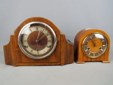 A wood cased mantel clock with Roman numeral chapter ring,