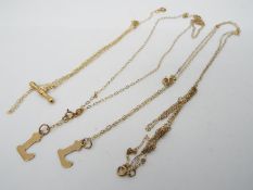Four delicate necklaces, two with the letter L, one with a bar plus one other stamped 375 all in 2.