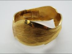 An 18ct yellow gold expanding bangle, stamped 750, approximately 33.7 grams all in.