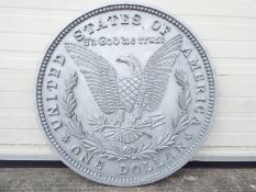 A large wooden sign depicting a one dollar coin,