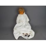 Antique doll- wax face, wooden limbs and stuffed body. Length 75cm.