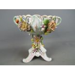A Von Schierholz porcelain centrepiece decorated with applied flowers and fruit,