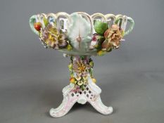 A Von Schierholz porcelain centrepiece decorated with applied flowers and fruit,