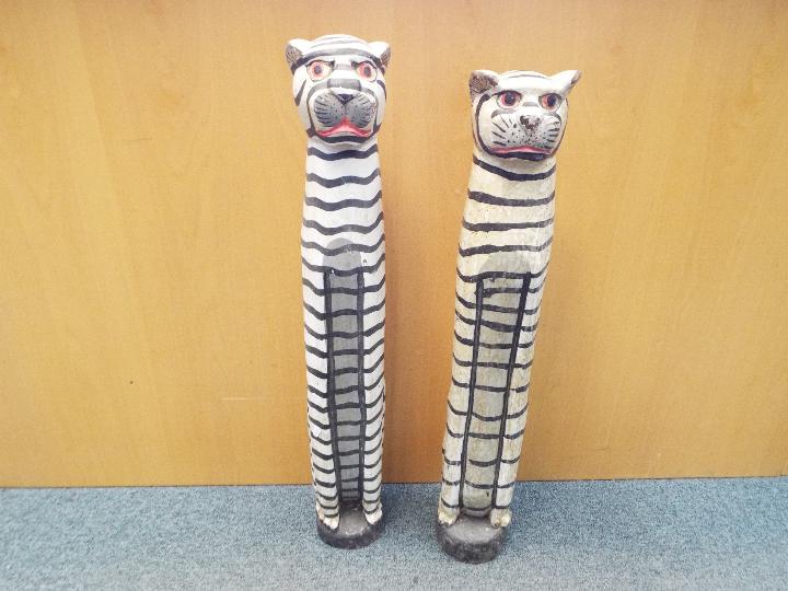 Two large painted wooden carvings depicting tigers, largest approximately 84 cm (h).