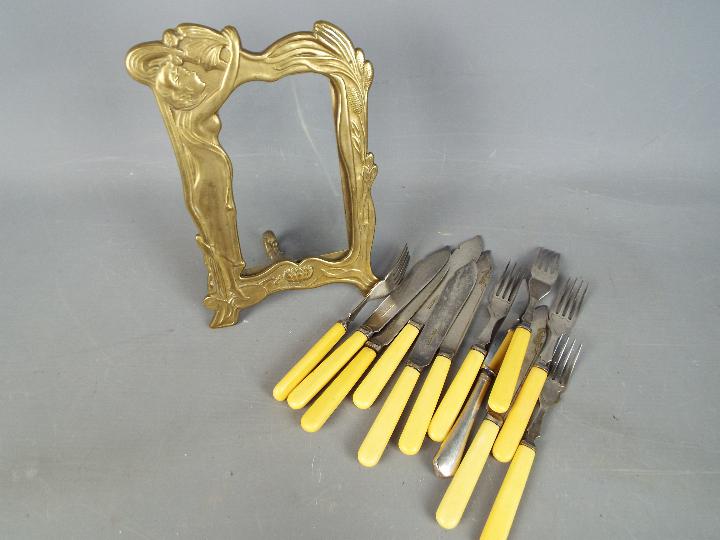 A art nouveau style picture frame and a quantity of fish knives and folks