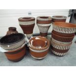 A collection of terracotta jardinieres, stands and planter.