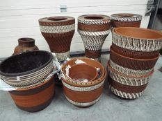 A collection of terracotta jardinieres, stands and planter.