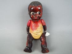 Celluloid Doll - a string jointed black Americana boy doll with black textured hair and kewpie eyes