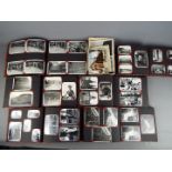 A collection of photograph albums containing black and white photographs including family pictures,