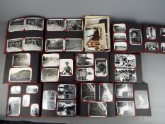 A collection of photograph albums containing black and white photographs including family pictures,