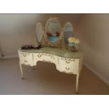 A cream painted kidney shaped dressing table in the French style,