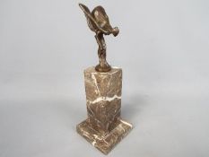 A bronzed flying lady in the form of Spirit of Ecstasy set on a marble plinth,