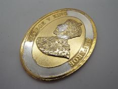 An oval silver and gold-plated medallion