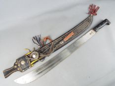 A large Central American machete in ornately decorated sheath, approximately 60 cm blade length.