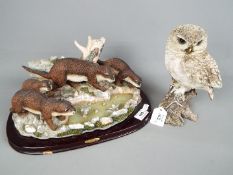 A Juliana Collection figural group depicting a family of otters fishing,