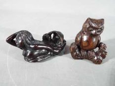 A vintage Japanese dark wood Netsuke depicting an Owl seated on a thick branch or log,