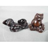 A vintage Japanese dark wood Netsuke depicting an Owl seated on a thick branch or log,