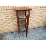 An Edwardian cuboid display cabinet, glazed on all sides with shelved interior on tapering supports,