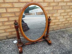 A mahogany framed oval swing mirror,
