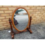 A mahogany framed oval swing mirror,