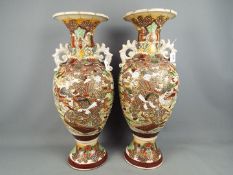 A pair of large twin handled vase of baluster form with moriage decoration depicting samurai in a