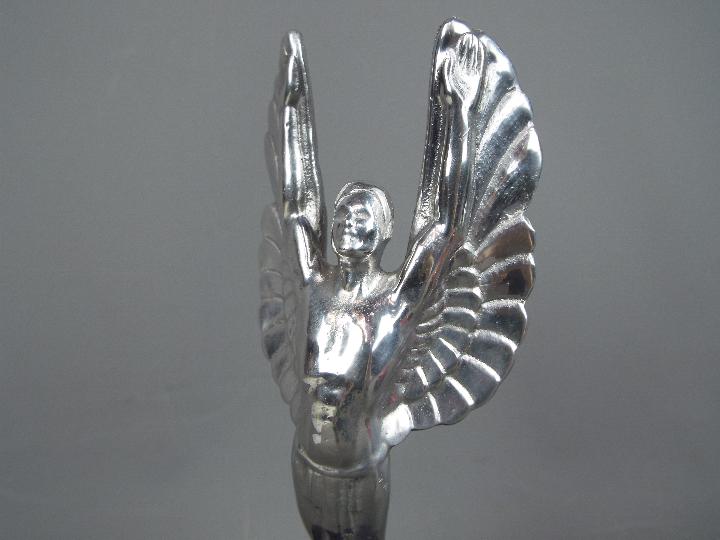 A chrome sculpture depicting a pair of angel wings set on a plinth, - Image 2 of 2