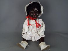 A large composition black girl doll with string jointed arms legs and head with sleeping brown eyes,