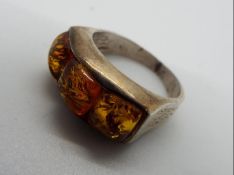 A silver dress ring set with Amber, size O and a half,