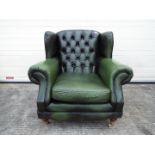 A green leather Chesterfield armchair.