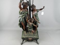 A large three light table lamp decorated with classical figures,