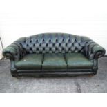 A green leather, three seat, Chesterfield sofa.